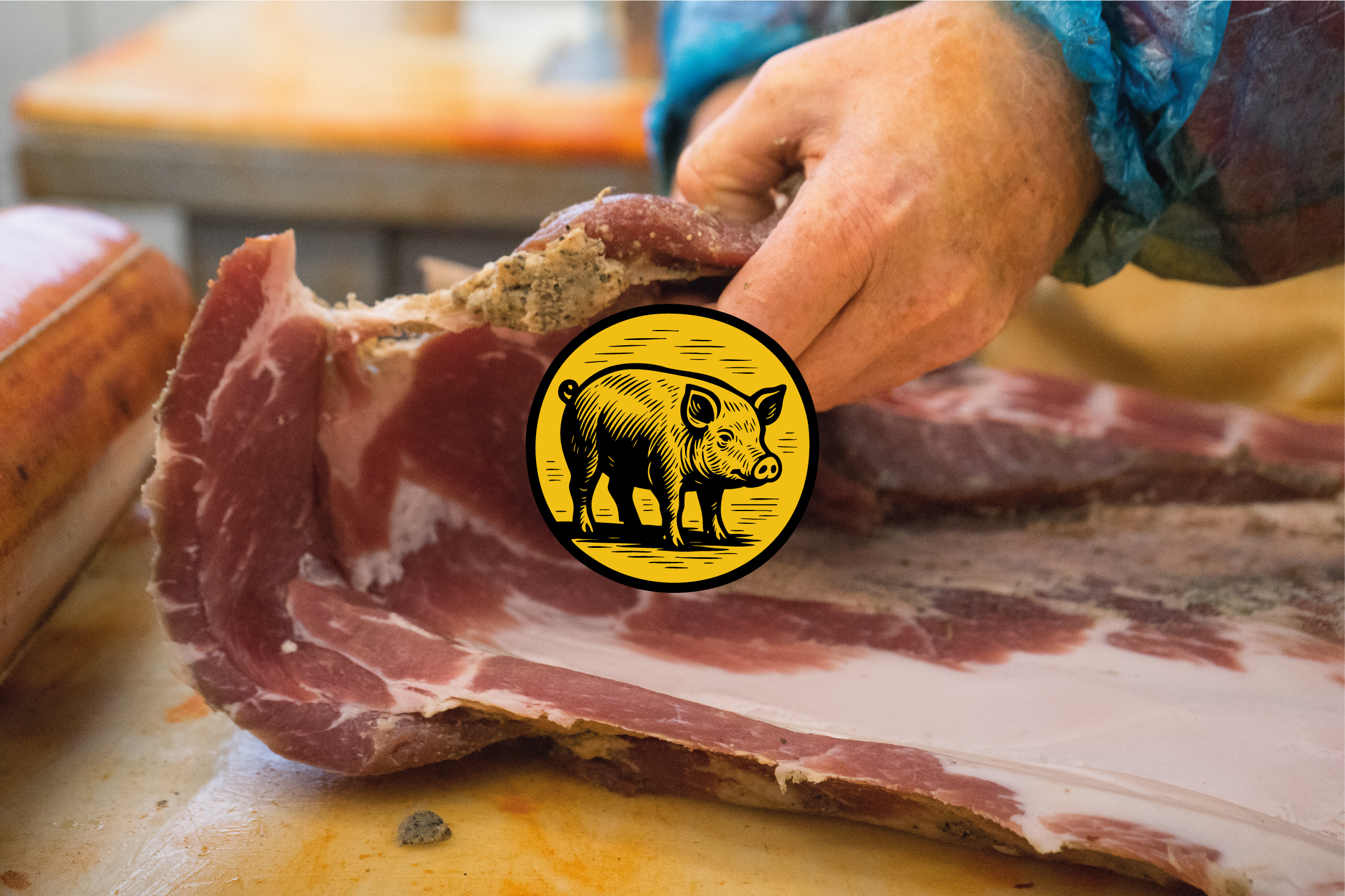 Macellaio che massaggia spezie su pancetta o taglio di carne cruda per salume